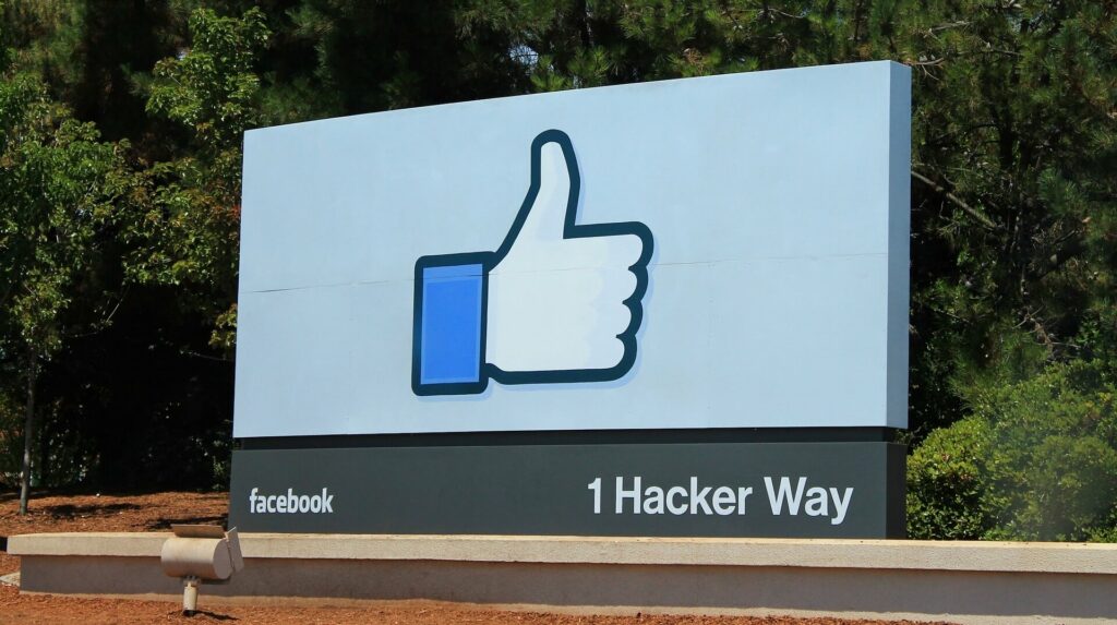 Facebook-Like-Button auf großem Schild vor Bäumen