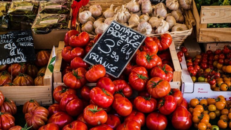 Kisten mit Tomaten + Knoblauch mit Preisschildern: Symbolbild für Grundpreis bei Gratiszugaben
