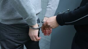 Haftbefehl wegen Fluchtgefahr: Eine Person legt einer anderen Person Handschellen an