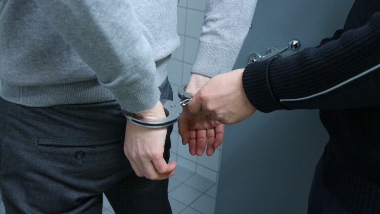 Haftbefehl wegen Fluchtgefahr: Eine Person legt einer anderen Person Handschellen an