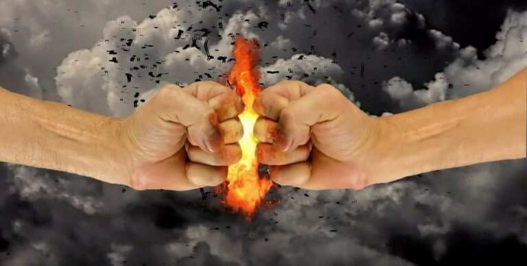 zwei Fäuste stoßen aneinander: Feuer, dunkle Wolken
